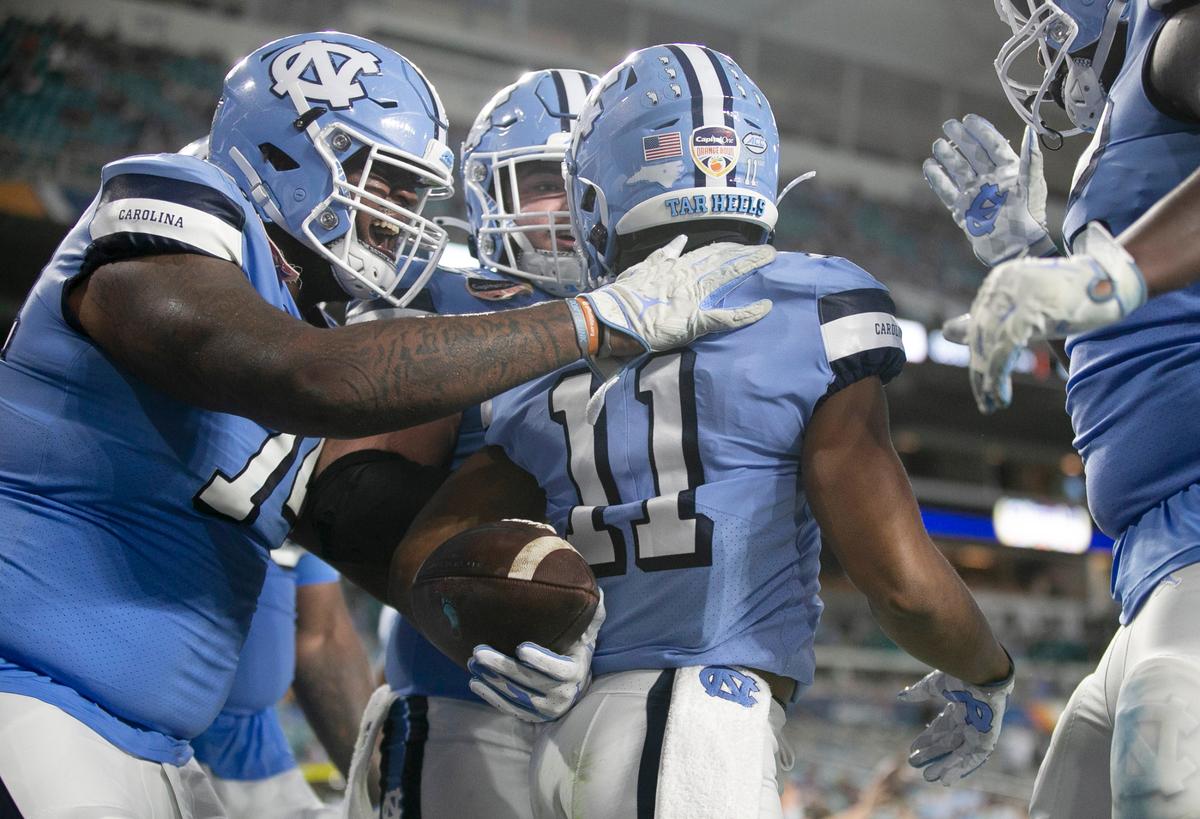 North Carolina’s Josh Downs (11) is surrounded by teammates after scoring a touchdown in the third quarter to give the Tar Heels’ a 20-17 lead over Texas A&M during the Capital One Orange Bowl on Saturday, January 2, 2021in Miami Gardens, Florida.