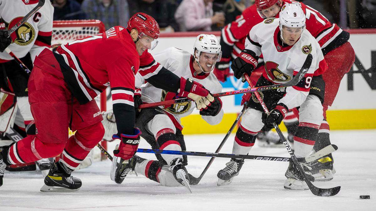Carolina Hurricanes’ Jordan Staal (11) and Ottawa’s Thomas Chabot (72) and Josh Norris (9) battle for the puck during the first period on Thursday, December 2, 2021 at PNC Arena in Raleigh, N.C.