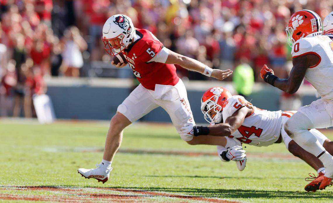 N.C. State’s Brennan Armstrong (5) escapes Clemson linebacker Jeremiah Trotter Jr. (54) on a run in the first half of N.C. State’s game against Clemson at Carter-Finley Stadium in Raleigh, N.C., Saturday, Oct. 28, 2023.
