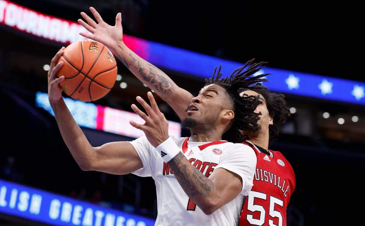 N.C. State’s Jayden Taylor (1) drives past Louisville’s Skyy Clark (55) during the second half of N.C. State’s 94-85 victory over Louisville in the first round of the 2024 ACC Men’s Basketball Tournament at Capital One Arena in Washington, D.C., Tuesday, March 12, 2024.