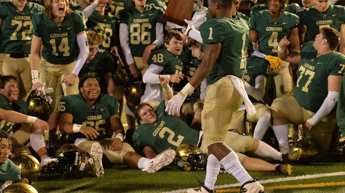 The Cardinal Gibbons football team reacts as Will Mason (1) walks over the East Regional Final trophy after their defeat of Rolesville. The Cardinal Gibbons Crusaders and the Rolesville Rams met in the NCHSAA 4A East Regional Final in Raleigh, N.C. on December 3, 2021