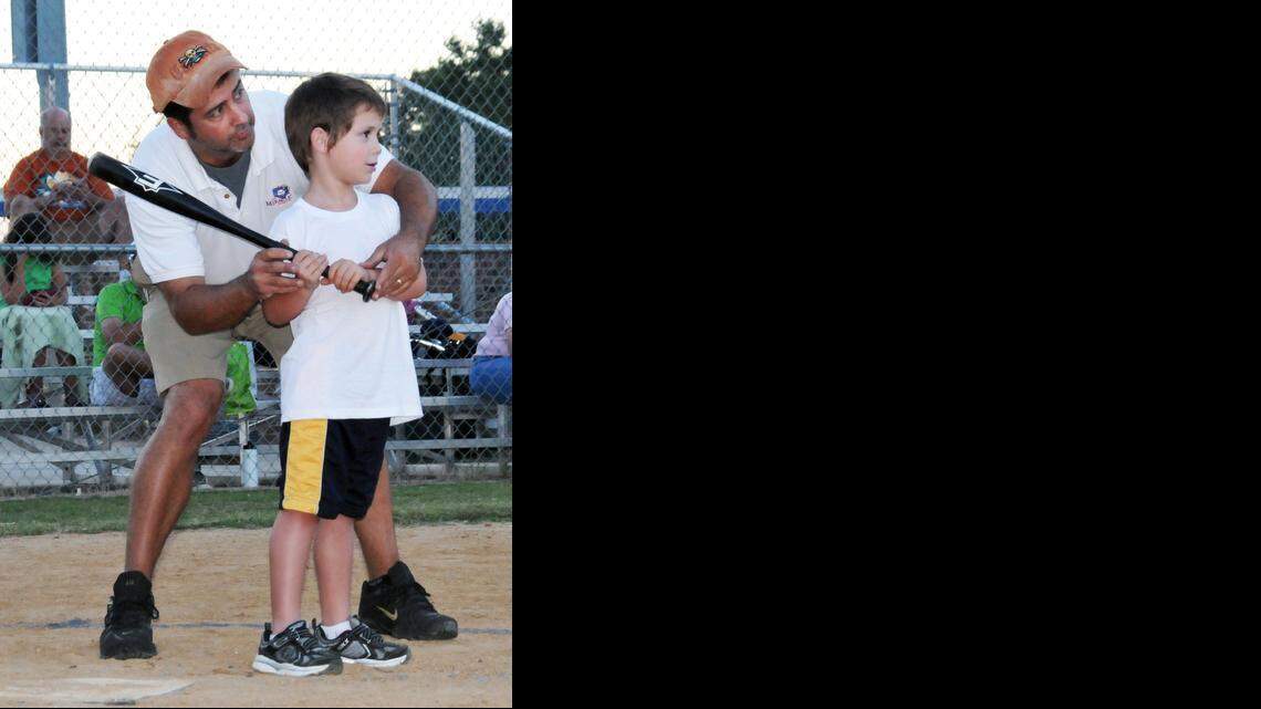 Monty McLamb helps Malaki Lubbers at the plate during a Miracle League game in Smithfield.
