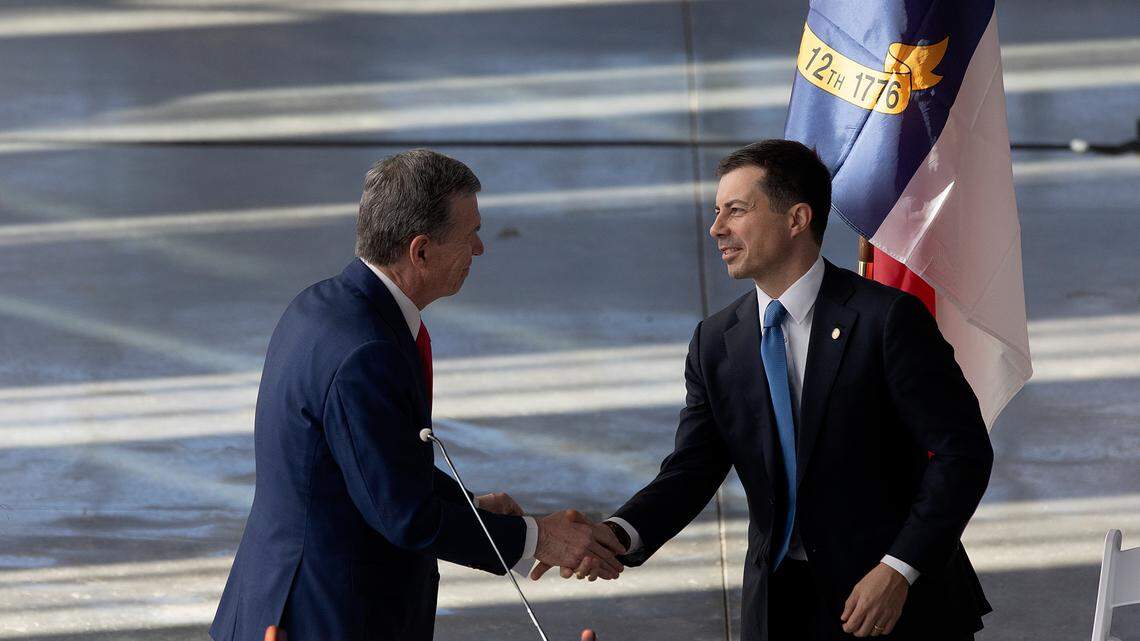 Gov. Roy Cooper shakes hands with U.S. Transportation Secretary Pete Buttigieg during an event at Raleigh Union Station on Dec. 11, 2023, to celebrate construction of the first leg of a high-speed rail line between the Triangle and Richmond, Va.