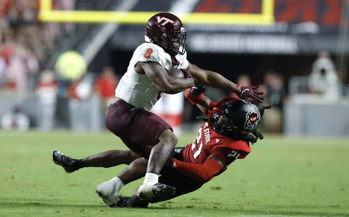 Virginia Tech running back Terion Stewart (8) rolls over N.C. State’s Jamel Johnson (21) during the second half of Virginia Tech’s 23-21 victory over N.C. State at Carter-Finley Stadium in Raleigh, N.C., Saturday, Sept. 27, 2025.