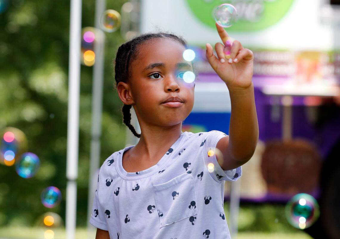 Maliah Bazzell, 6, of Knightdale plays with bubbles during the Capital City Juneteenth Celebration 2021 at Dorothea Dix Park in Raleigh, N.C., Saturday, June 19, 2021.