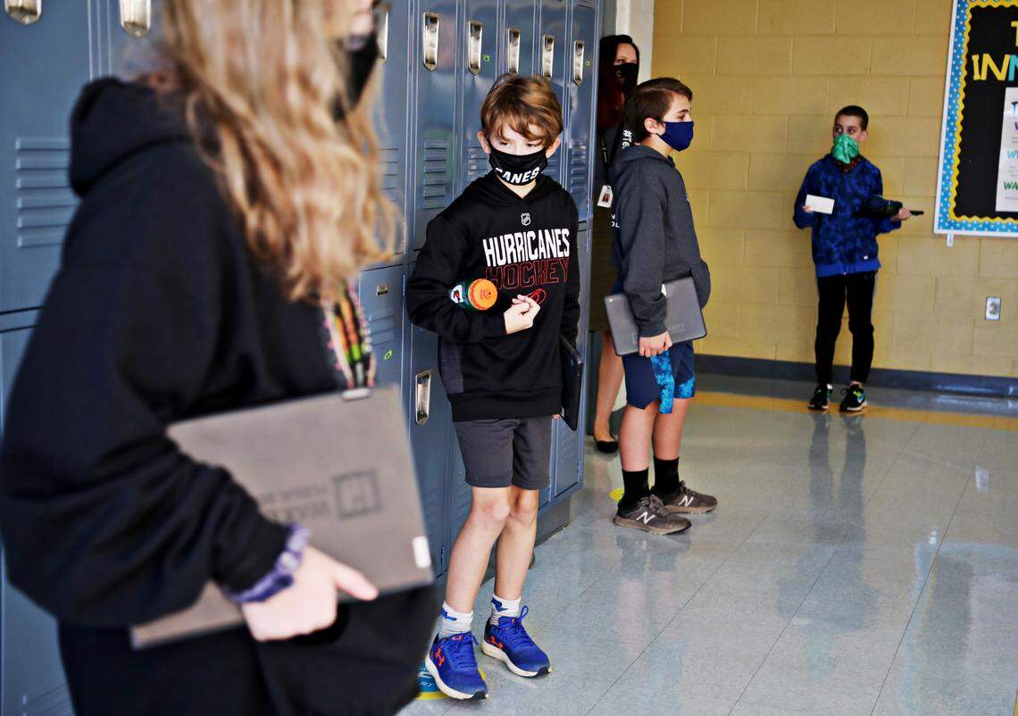 Carroll Middle School sixth-graders are spaced out in a hallway before going to their second period class on the first day of in-person school for some students on Monday, Nov. 9, 2020.