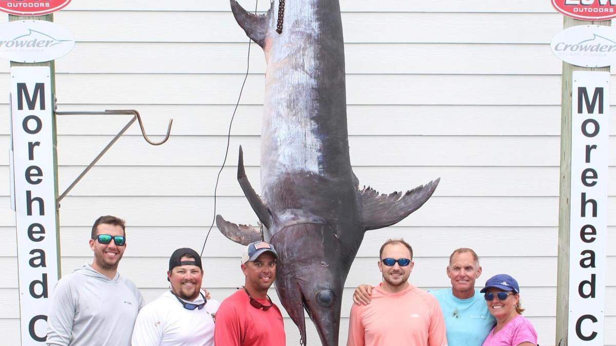 Cary Carney of Newport, NC, poses with the state-record swordfish he caught on his son Brandon Carney’s boat off Morehead City in August.