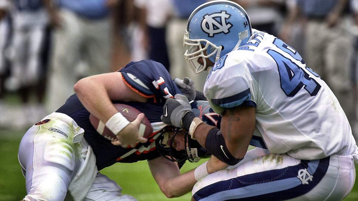 UNC defensive end Julius Peppers drags down Virginia quarterback Dan Ellis in 2000.