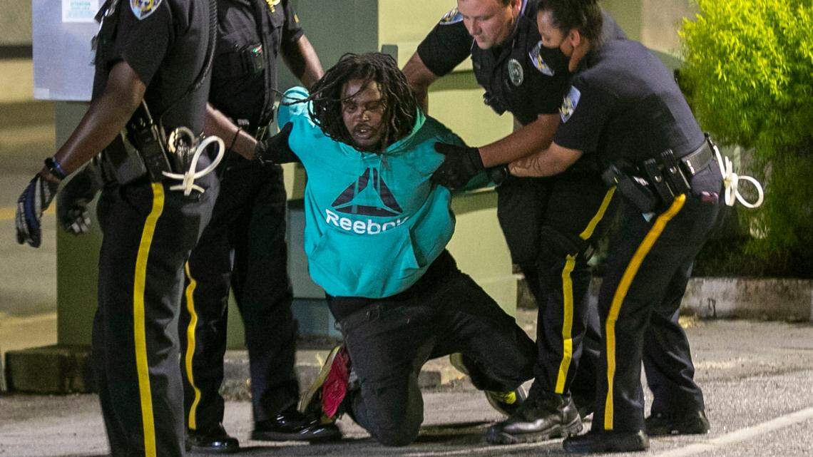 Elizabeth City Police arrest a demonstrator in the municipal building parking after 11 p.m. on Wednesday, April 28, 2021 in Elizabeth City, N.C. Five people were arrested for violating the 8 p.m. curfew, one week after Andrew Brown Jr.’s death at the hands of Pasquotank County deputies.