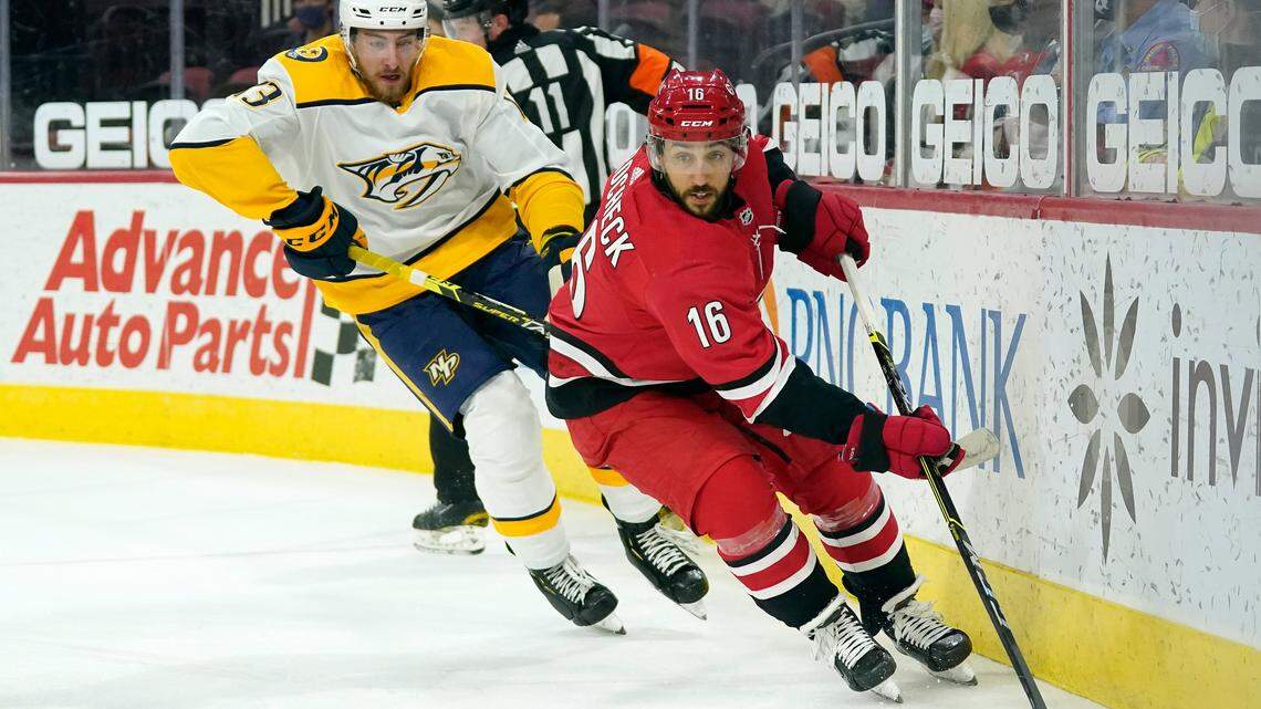 Carolina Hurricanes center Vincent Trocheck (16) controls the puck while Nashville Predators center Yakov Trenin (13) chases during the first period of an NHL hockey game in Raleigh, N.C., Saturday, April 17, 2021. (AP Photo/Gerry Broome)