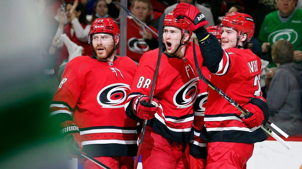 Carolina Hurricanes’ Martin Necas (88) celebrates his goal with teammates Ian Cole (28), left, and Andrei Svechnikov (37) during the second period of an NHL hockey game against the Vancouver Canucks in Raleigh, N.C., Saturday, Jan. 15, 2022. (AP Photo/Karl B DeBlaker)