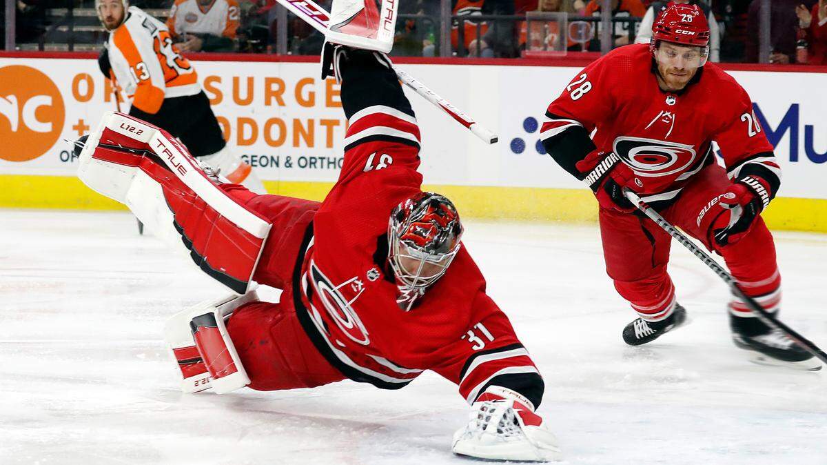 Carolina Hurricanes goaltender Frederik Andersen (31) dives on the puck that was shot by Philadelphia Flyers’ Kevin Hayes (13) with Hurricanes’ Ian Cole (28) nearby during the first period of an NHL hockey game in Raleigh, N.C., Saturday, March 12, 2022. (AP Photo/Karl B DeBlaker)