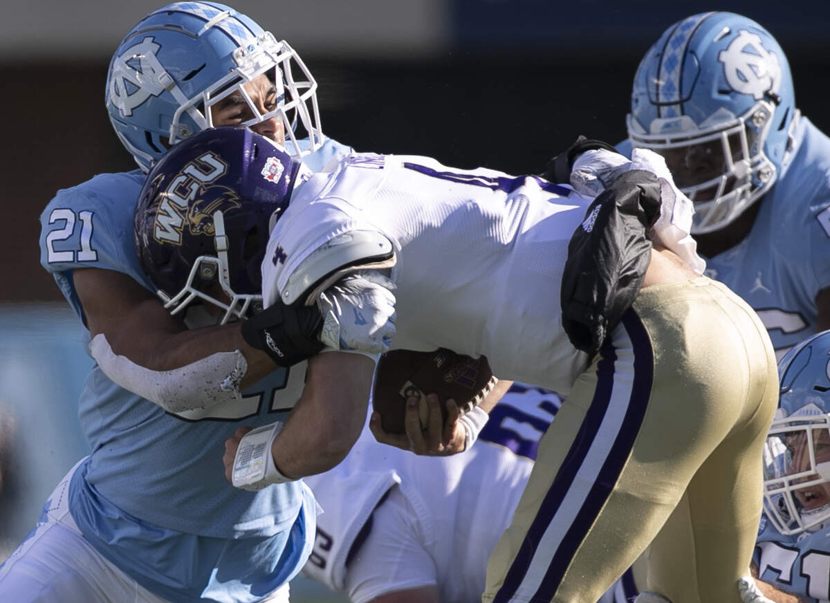 North Carolina linebacker Chazz Surratt (21) stops Western Carolina quarterback Kason Lincke (4) in the second quarter on Saturday, December 5, 2020 at Kenan Stadium in Chapel Hill, N.C.