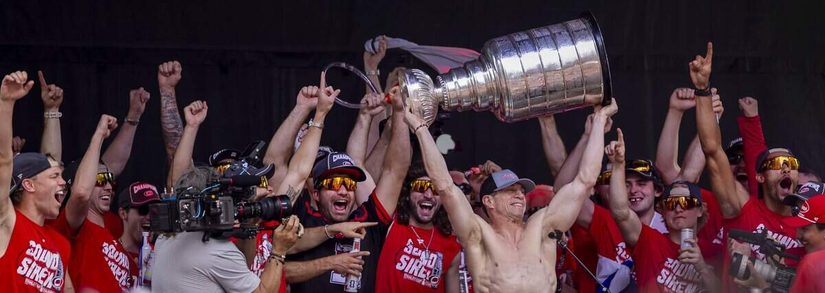 A shirtless Carolina Hurricanes head coach Rod Brind’Amour, hoists the Stanley Cup during the celebration rally on the City Plaza on Saturday, June 20, 2026 in Raleigh, NC.