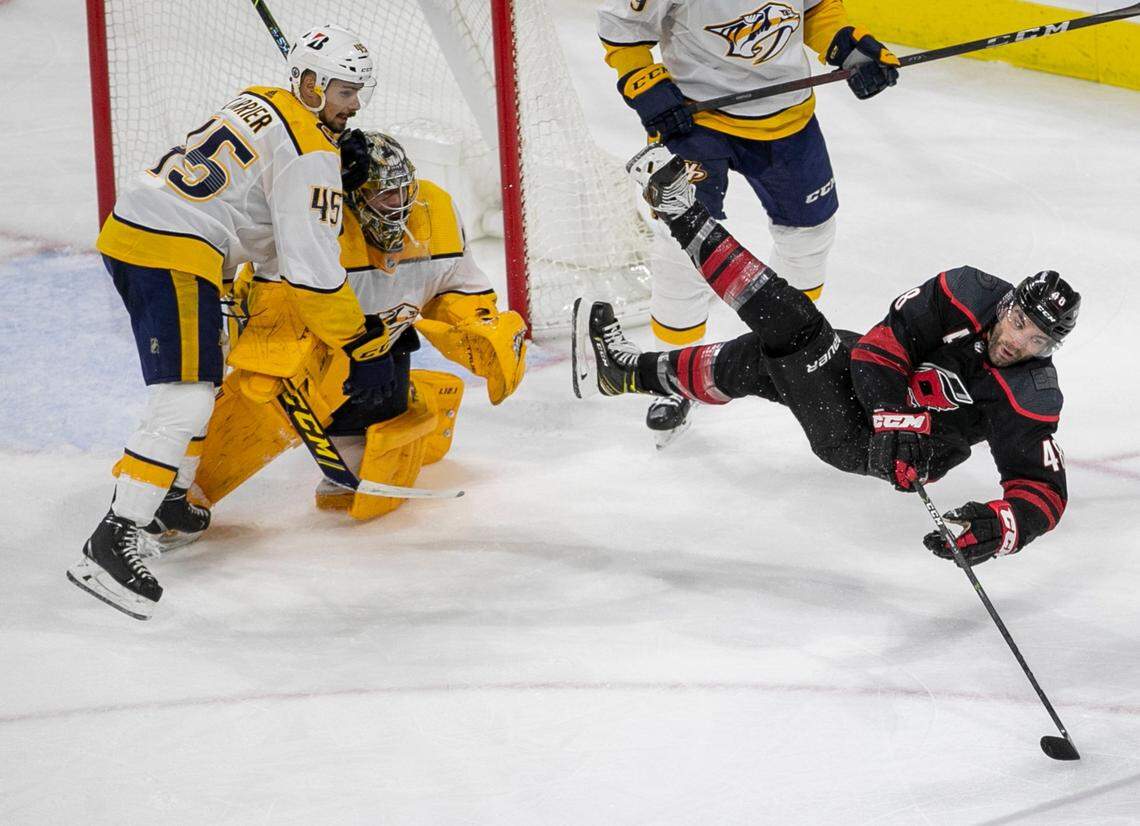 Carolina Hurricanes’s Jordan Martinook (48) is upended in front of Nashville goalie Juuse Saros (74) in the second period of game five in their first round Stanley Cup Series on Tuesday, May 25, 2021 at PNC Arena in Raleigh, N.C.