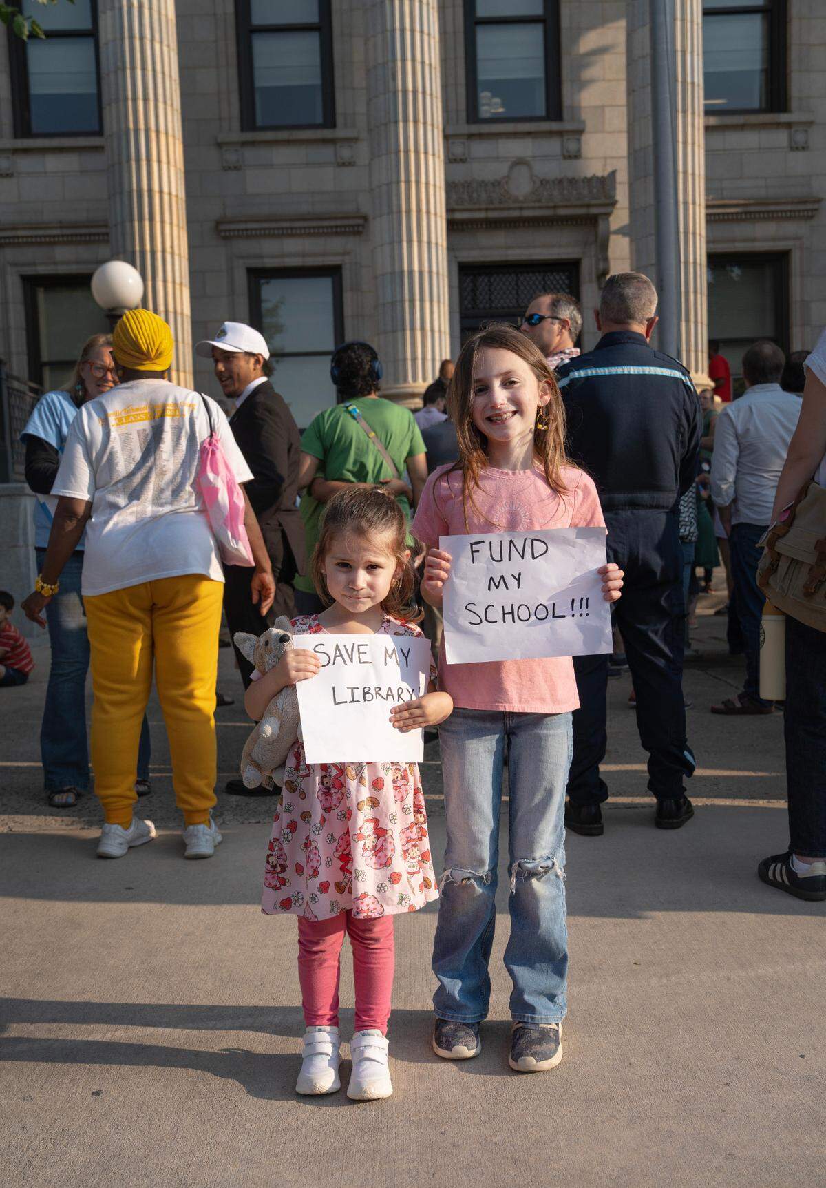 Sisters Abigail and Sophia stand for a portrait during the rally outside the Alamance County Courthouse in Graham, N.C. on June 2, 2025. People gathered to protest budget cuts for the library system and its social services.