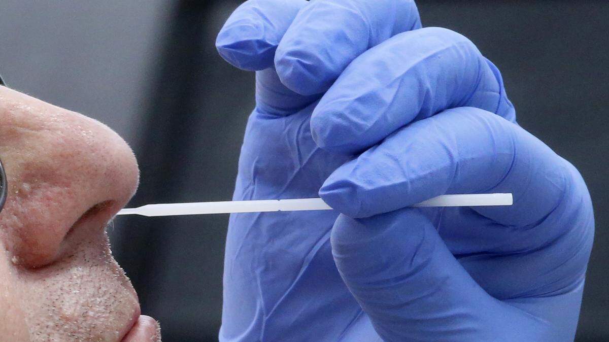 FILE - In this Friday, June 12, 2020 file photo, a nurse uses a swab to perform a coronavirus test in Salt Lake City. Months into the outbreak, no one really knows how well many of the screening tests work, and experts at top medical centers say it is time to do the studies to find out. (AP Photo/Rick Bowmer)