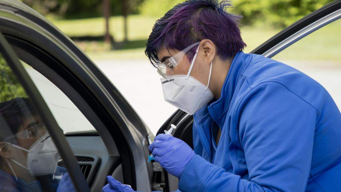 Elsa Pantoja Garcia administers a Moderna COVID-19 vaccine to someone seated on the passenger side of a car at a temporary free drive-thru vaccine site, that is normally a free drive-thru testing site, at the Wendell Community Center, on Thursday, Apr. 22, 2021, in Wendell, N.C.