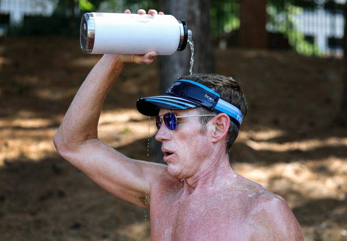 Van Fletcher, 49, of Raleigh, cools down as he takes a break from training at N.C. State’s Paul Derr Track and Field facility in Raleigh, N.C., at 10:30 Wednesday morning June 26, 2024. Fletcher was running 11 miles as part of his training for two upcoming Ironman competitions. Regarding running in the heat, Fletcher said, “In ideal world I get here at six (am). But I don’t work in an ideal world.” Fletcher took breaks and hydrated frequently.