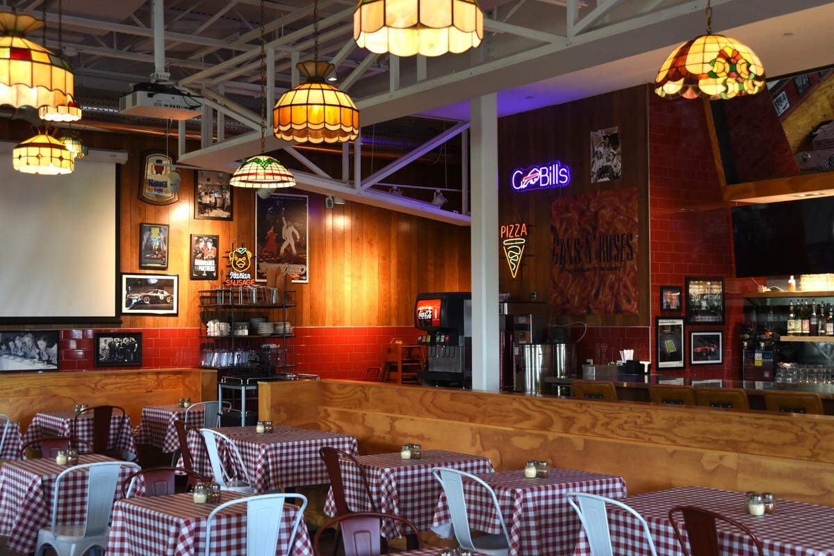 Tiffany lamps hang from above and Saturday Night Fever hangs on the walls at the new Dino’s Pizza.
