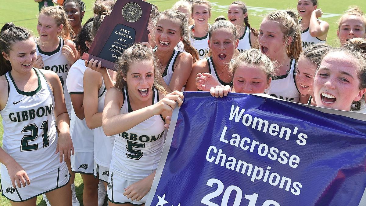 Cardinal Gibbons’ Caroline Kimel (8) holds the State Championship trophy and celebrates with teammates after their defeat of Charlotte Catholic for the NCSHAA 2019 Women’s Lacrosse Championship. The Cardinal Gibbons Crusaders and the Charlotte Catholic Cougars met in the NCHSAA Women’s lacrosse championship at WakeMed Soccer Park in Cary, N.C. on May 17, 2019.