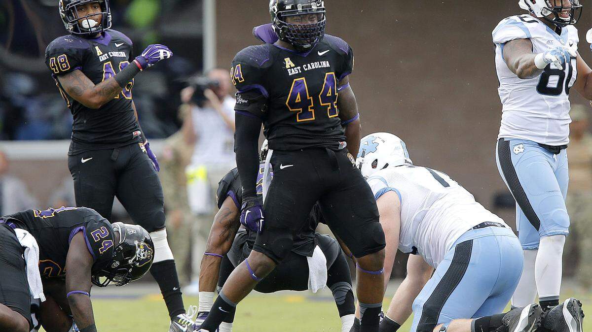 East Carolina linebacker Zeek Bigger, middle, celebrates after stopping North Carolina’s Romar Morris, not shown, during the Pirates 70-41 over the Tar Heels on Sept. 20, 2014.