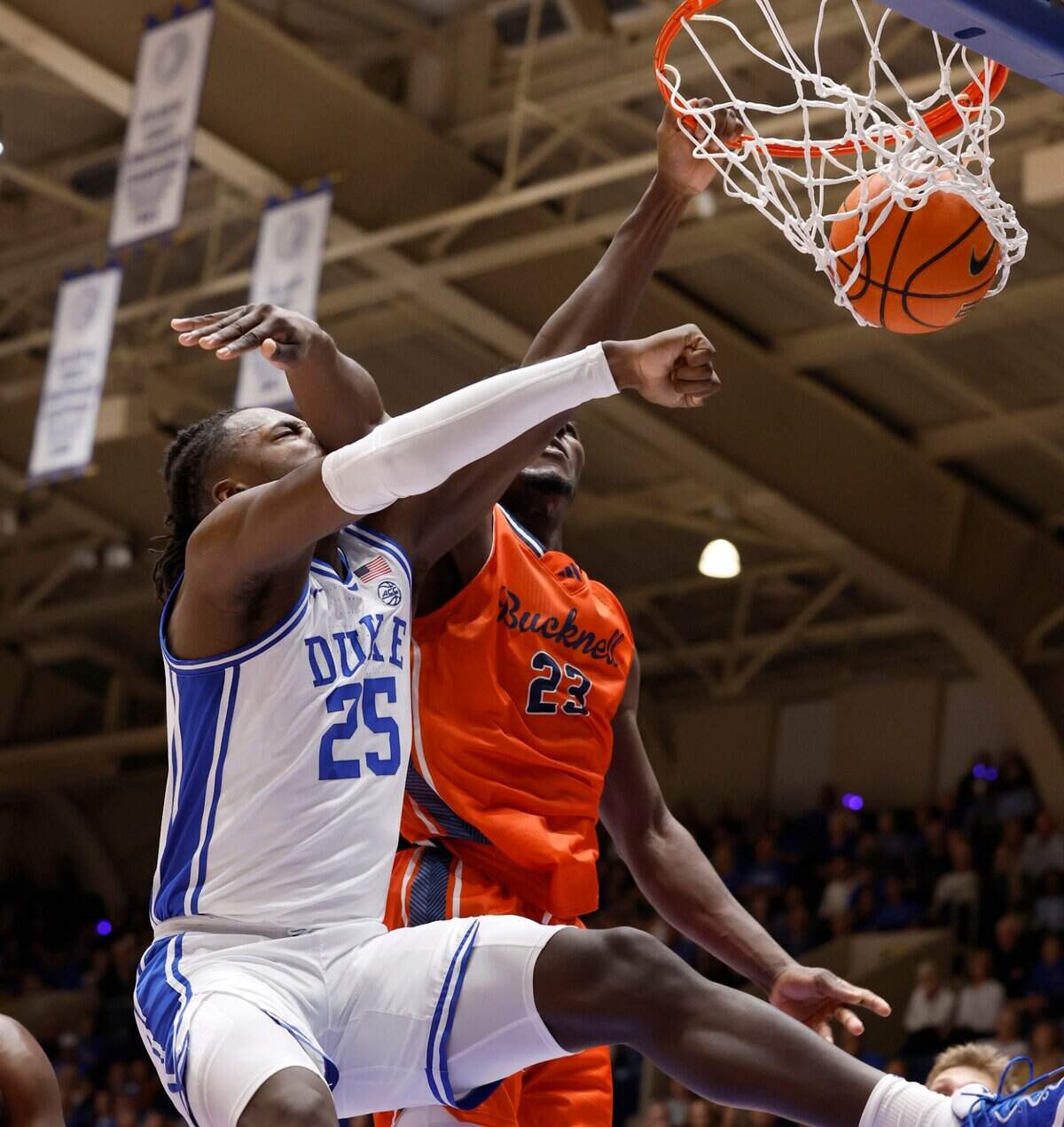 Duke’s Mark Mitchell (25) slams in two over the defense of Bucknell’s Pip Ajayi (23) during the first half of Duke’s game against Bucknell at Cameron Indoor Stadium in Durham, N.C., Friday, Nov. 17, 2023.