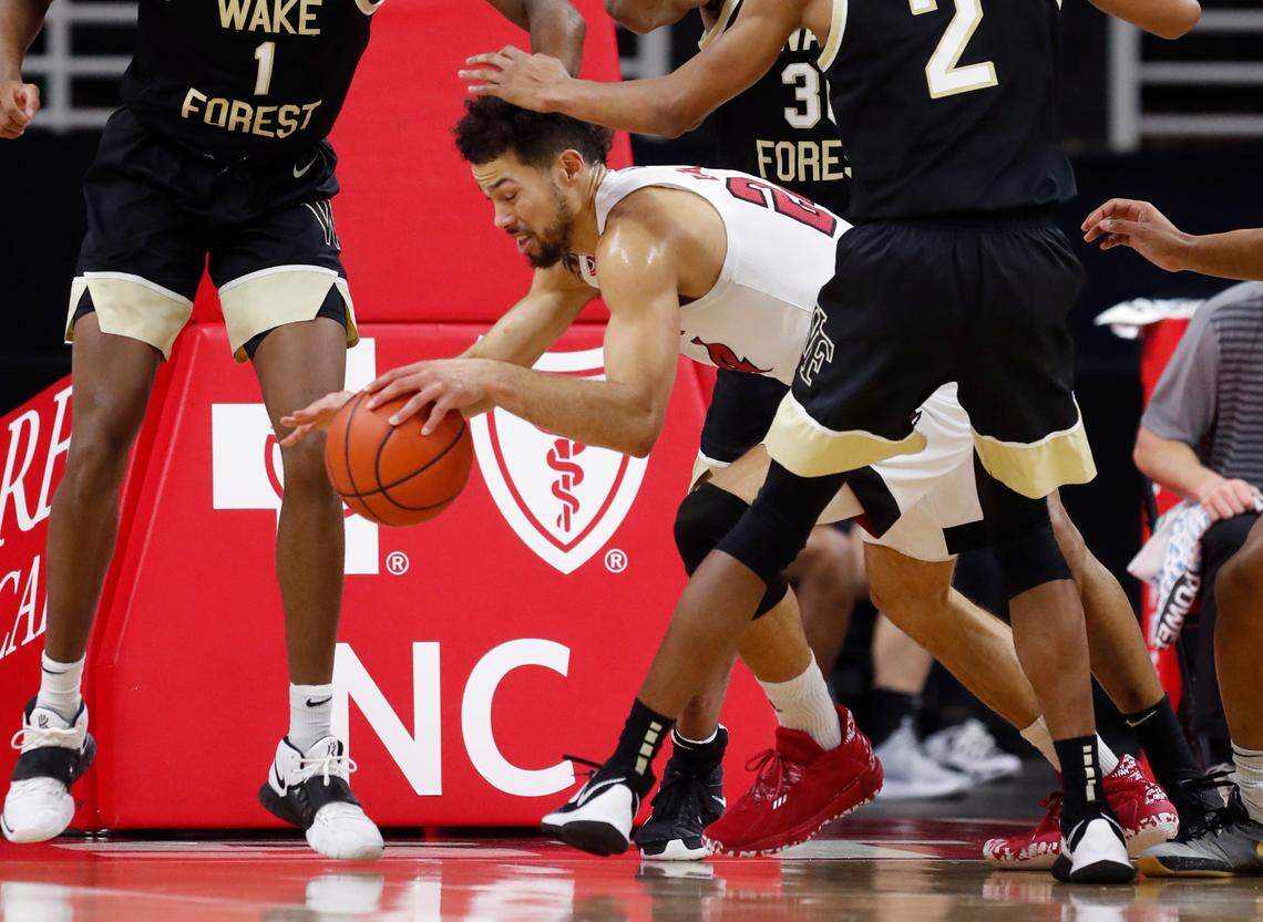 N.C. State’s Devon Daniels (24) escapes the pressure from Wake Forest defenders during the first half of N.C. State’s game against Wake Forest at PNC Arena in Raleigh, N.C., Wednesday, January 27, 2021.