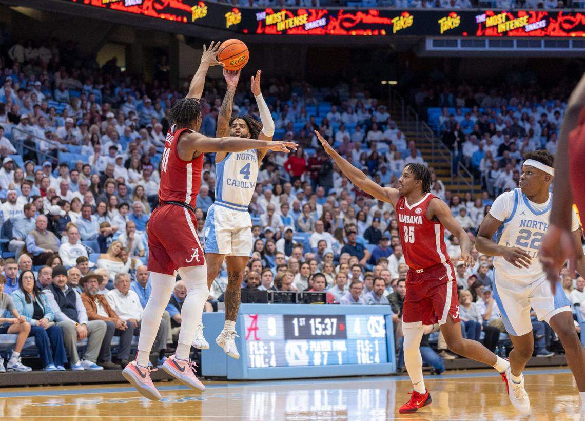 North Carolina guard R.J. Davis (4) launches a three-point shot under pressure from Alabama forward Mouhamed Dioubate (10) in the first half on Wednesday, December 4, 2024 at the Smith Center in Chapel Hill, N.C. Davis scored 18 points but was 1-11 from the three point arc.