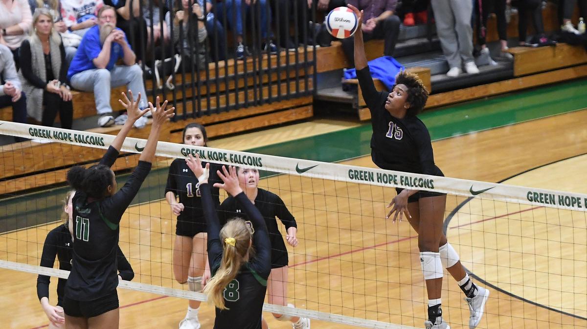 Jade Demps (15) of Broughton spikes the ball over the net against Priscilla Jones (11) and Sophia Kruczko (8) of Green Hope. The Broughton Capitals visited the Green Hope Falcons in a high school volleyball game on November 6, 2019.