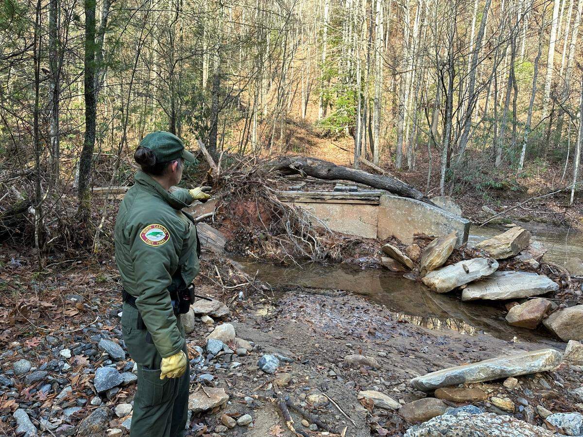 Ranger Mary Griffin points to where Shinny Creek washed out the approach to a bridge in South Mountains State Park. The park is closed indefinitely because many trails and unpaved roads were washed out by the remnants of Hurricane Helene on Sept. 27.