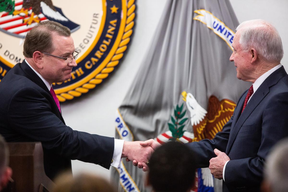 U.S. Attorney for the Eastern District of North Carolina, Robert J. Higdon Jr., left, shakes hands with U.S. Attorney General Jeff Sessions, before Sessions spoke about the Trump administration's plan to combat the nation's opioid crisis Tuesday, April 17, 2018, at the U.S. Attorney's Office for the Eastern District of North Carolina in Raleigh.