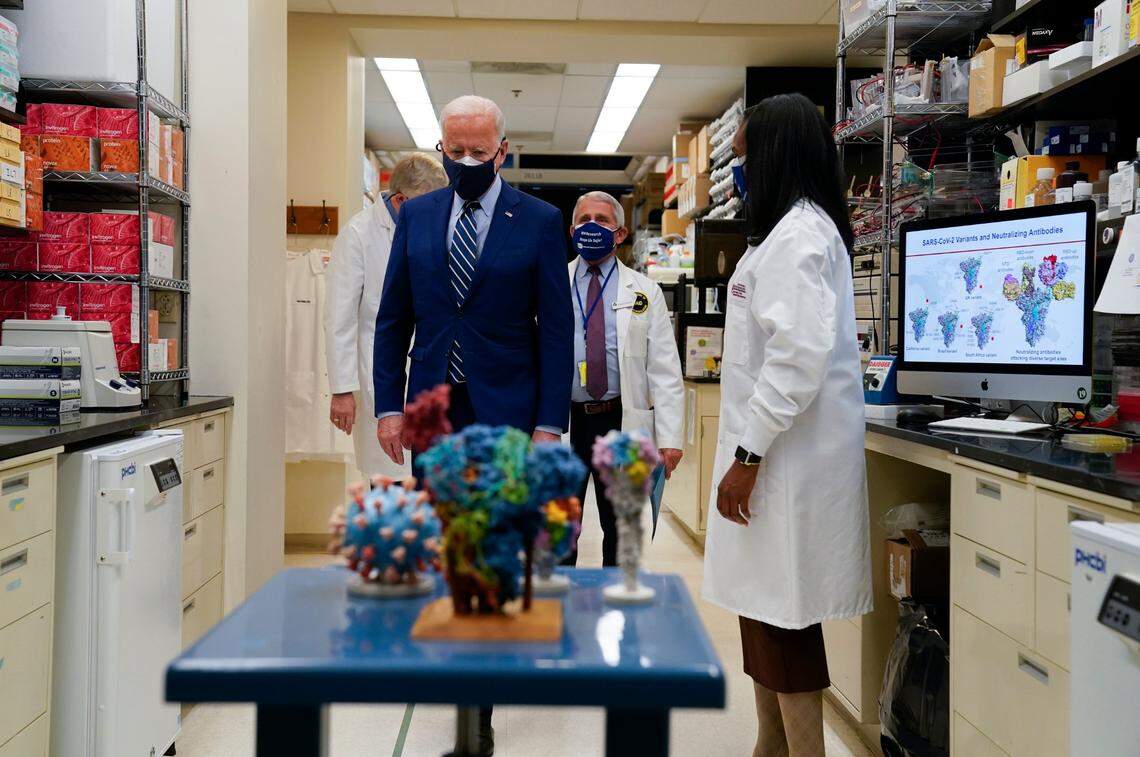 President Joe Biden visits the Viral Pathogenesis Laboratory at the National Institutes of Health, Thursday, Feb. 11, 2021, in Bethesda, Md. Kizzmekia Corbett, an immunologist with the Vaccine Research Center at the NIH looks on at right.