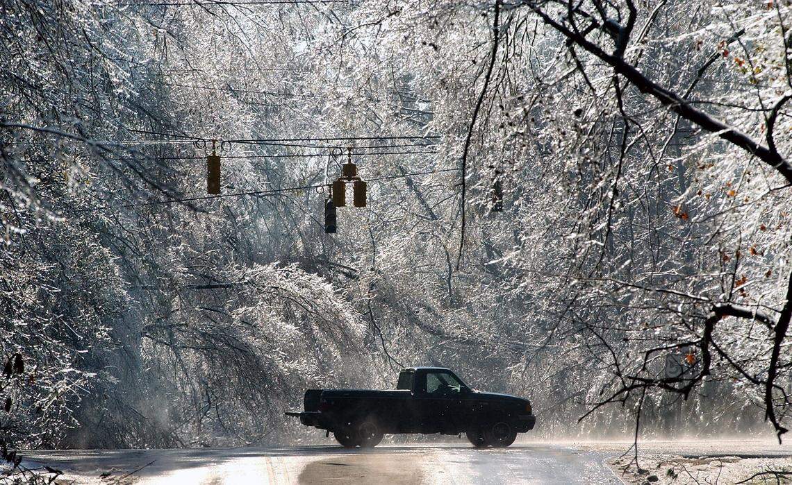 A truck is silhouetted under inactive traffic lights and downed power lines after an ice storm coated much of the Triangle leaving many residents without power for up to a week. 