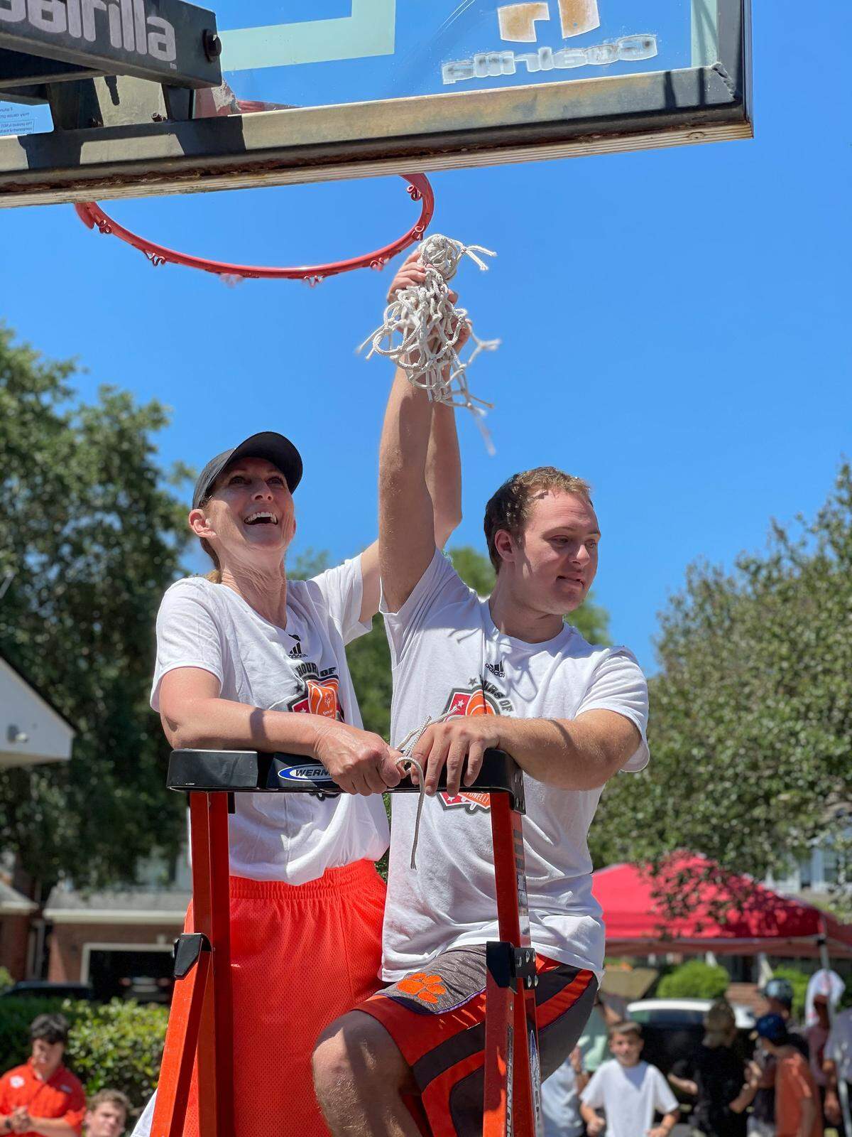 Debbie Antonelli and her son, Frankie, hold the net after cutting it down during her 24 Hour Nothing But Net free-throw shooting fundraiser to support the Special Olympics.