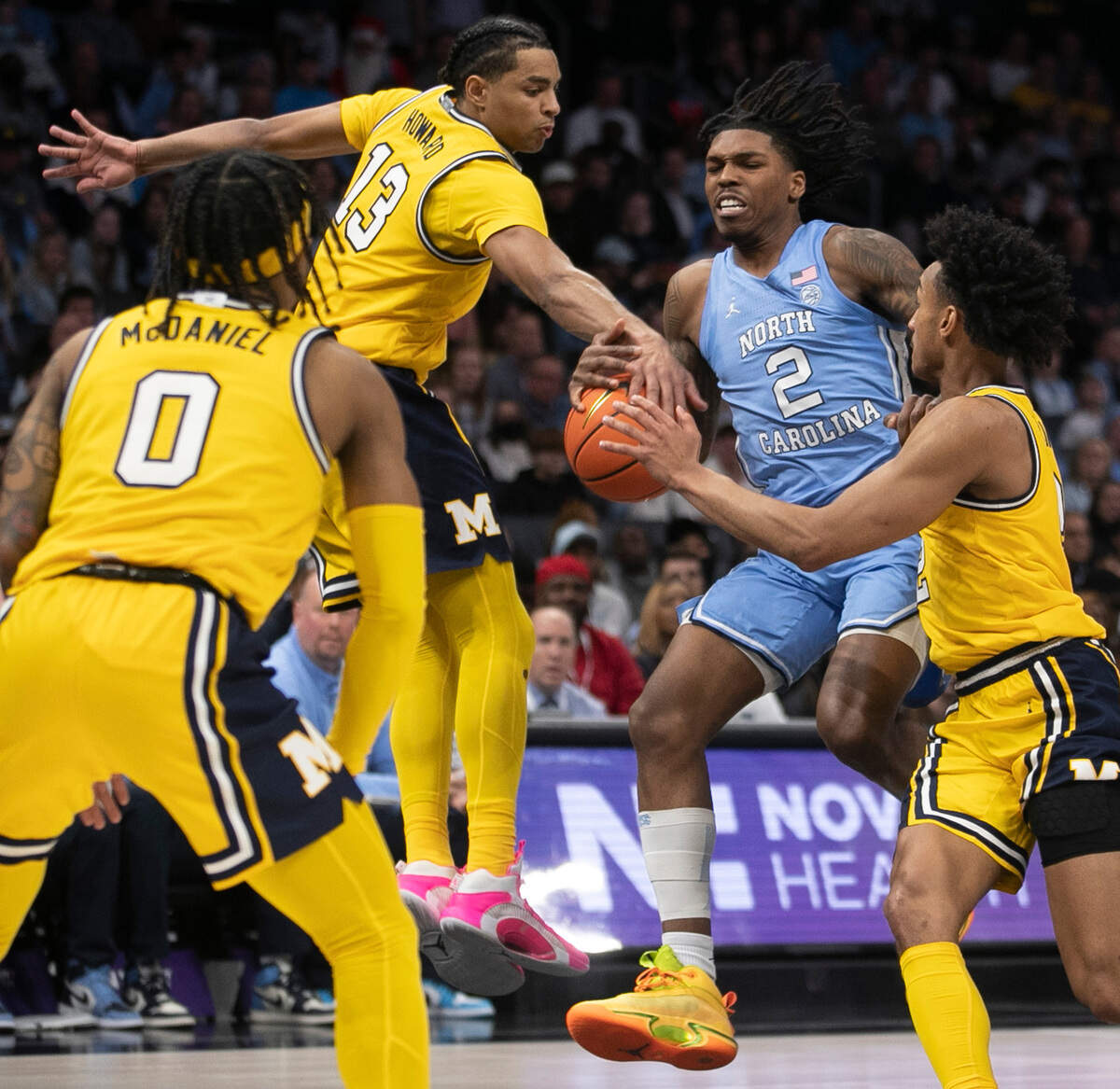 North Carolina’s Caleb Love (2) drives into a trap by Michigan’s Dug McDaniel (0), Jett Howard (13) and Kobe Bufkin (2) in the second half on Wednesday, December 21, 2022 at the Spectrum Center in Charlotte, N.C.
