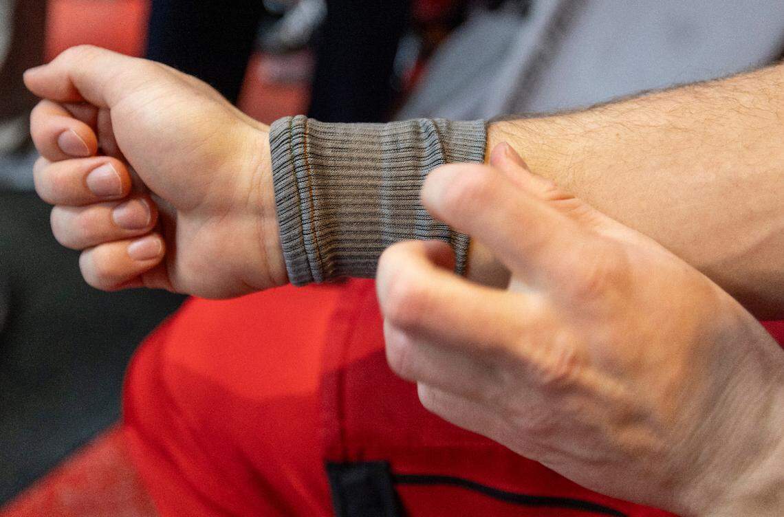Carolina Hurricanes defenseman Dylan Coghlan (15) shows the Kevlar sleeve he wears to protect his wrist from a skate cut following practice on Thursday, May 2, 2024 at PNC Arena in Raleigh, N.C.