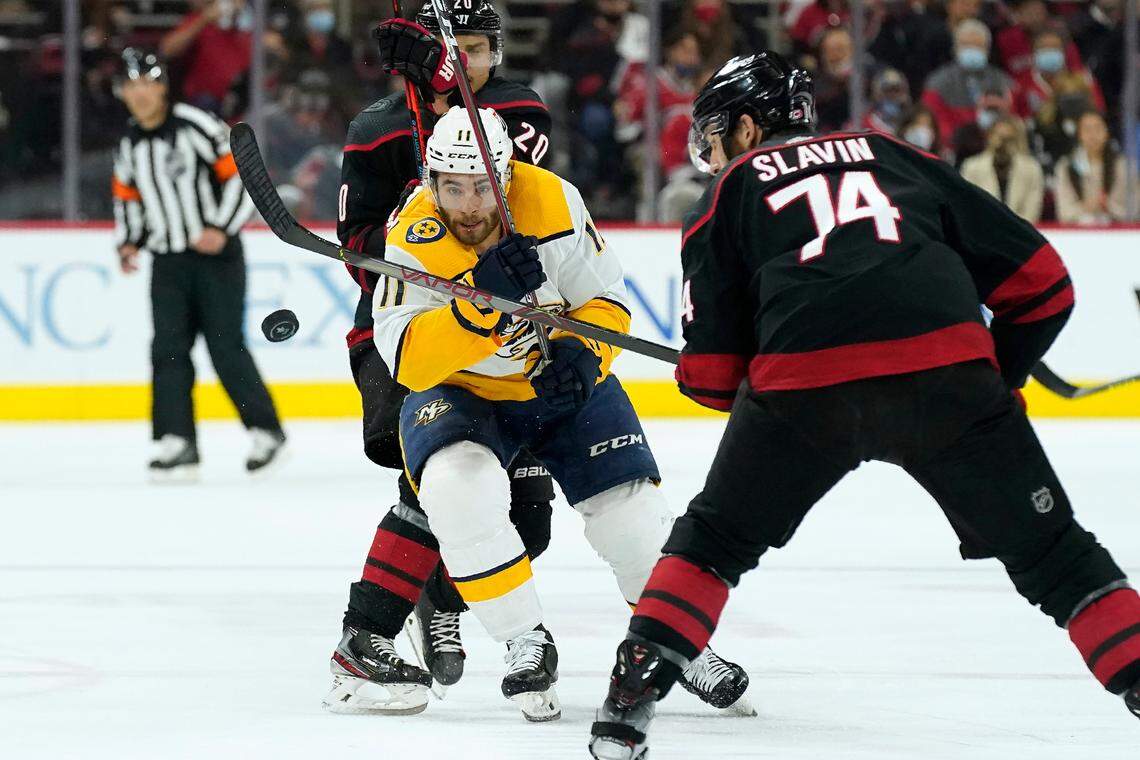 Nashville Predators center Luke Kunin (11) skates against Carolina Hurricanes defenseman Jaccob Slavin (74) during the first period in Game 5 of an NHL hockey Stanley Cup first-round playoff series in Raleigh, N.C., Tuesday, May 25, 2021. (AP Photo/Gerry Broome)