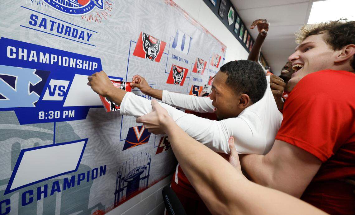 N.C. State’s KJ Keatts is lifted to put the Wolfpack sticker on the wall after N.C. State’s 72-65 overtime victory over Virginia in the semifinals of the 2024 ACC Men’s Basketball Tournament at Capital One Arena in Washington, D.C., Friday, March 15, 2024.