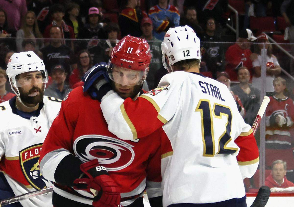 Eric Staal (12) of the Florida Panthers hangs on to his brother, Jordan Staal, of the Carolina Hurricanes in Game 1 of the Eastern Conference Final of the 2023 Stanley Cup Playoffs at PNC Arena on May 19, 2023 in Raleigh, North Carolina.
