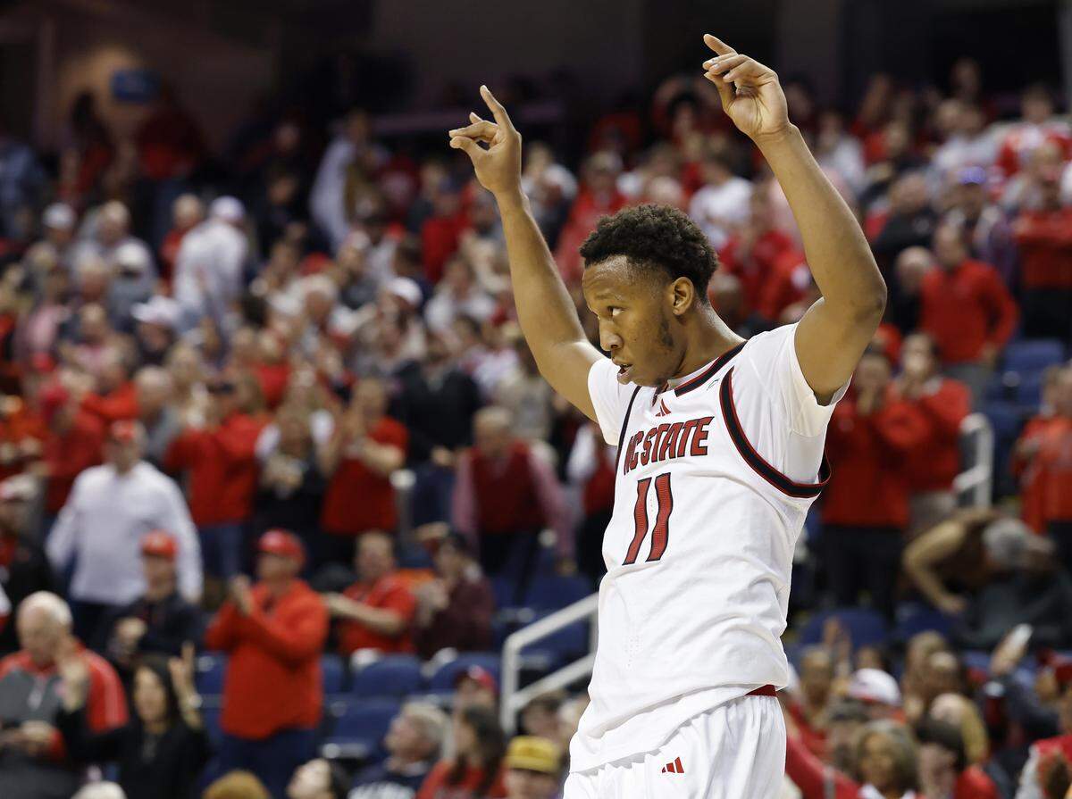 N.C. State’s Quadir Copeland makes the Wolfpack sign during the closing seconds of the team’s 76-62 win over Ole Miss on Dec. 21, at First Horizon Coliseum in Greensboro, N.C.