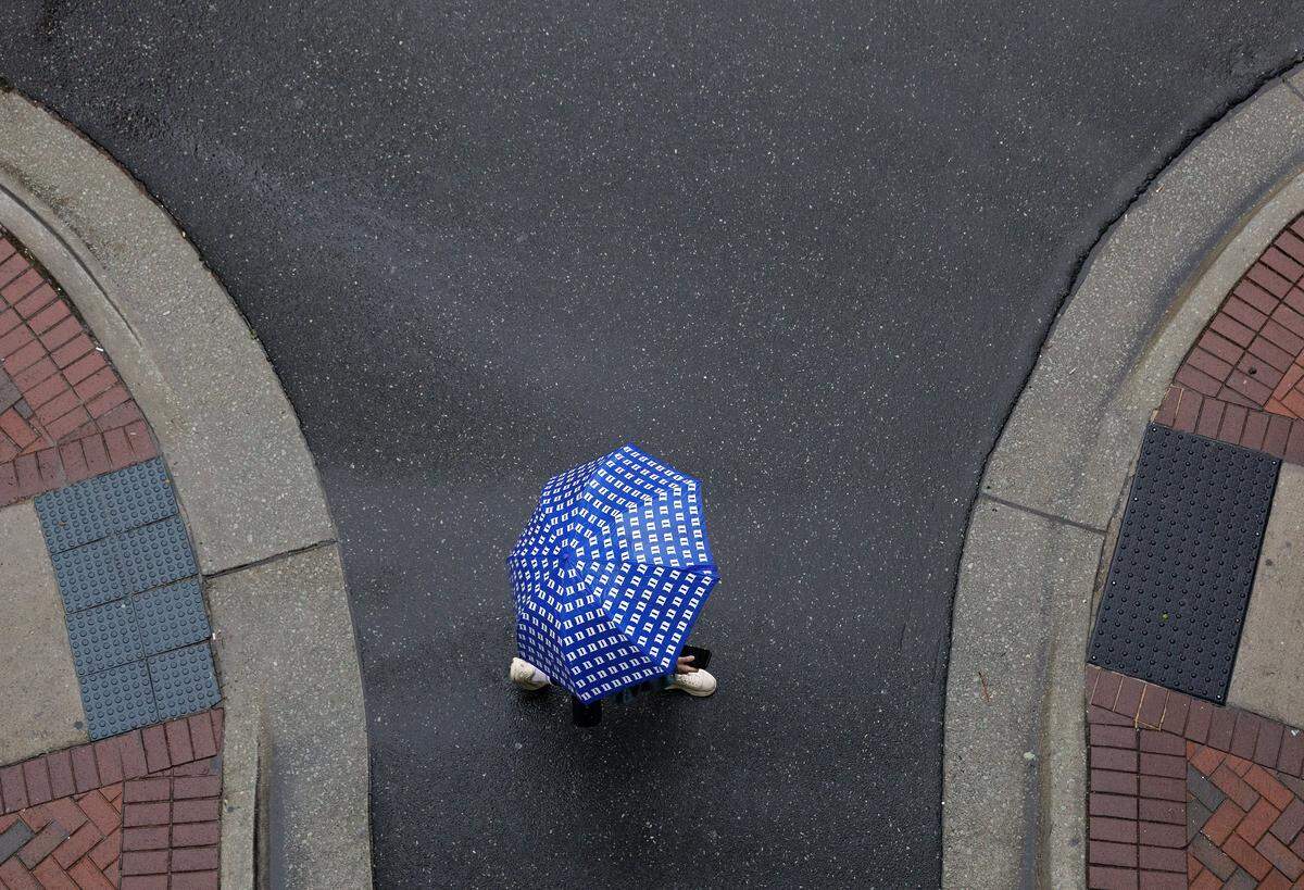 A person walks with an umbrella as rain falls in downtown Durham, N.C. on Thursday, May 7, 2026.