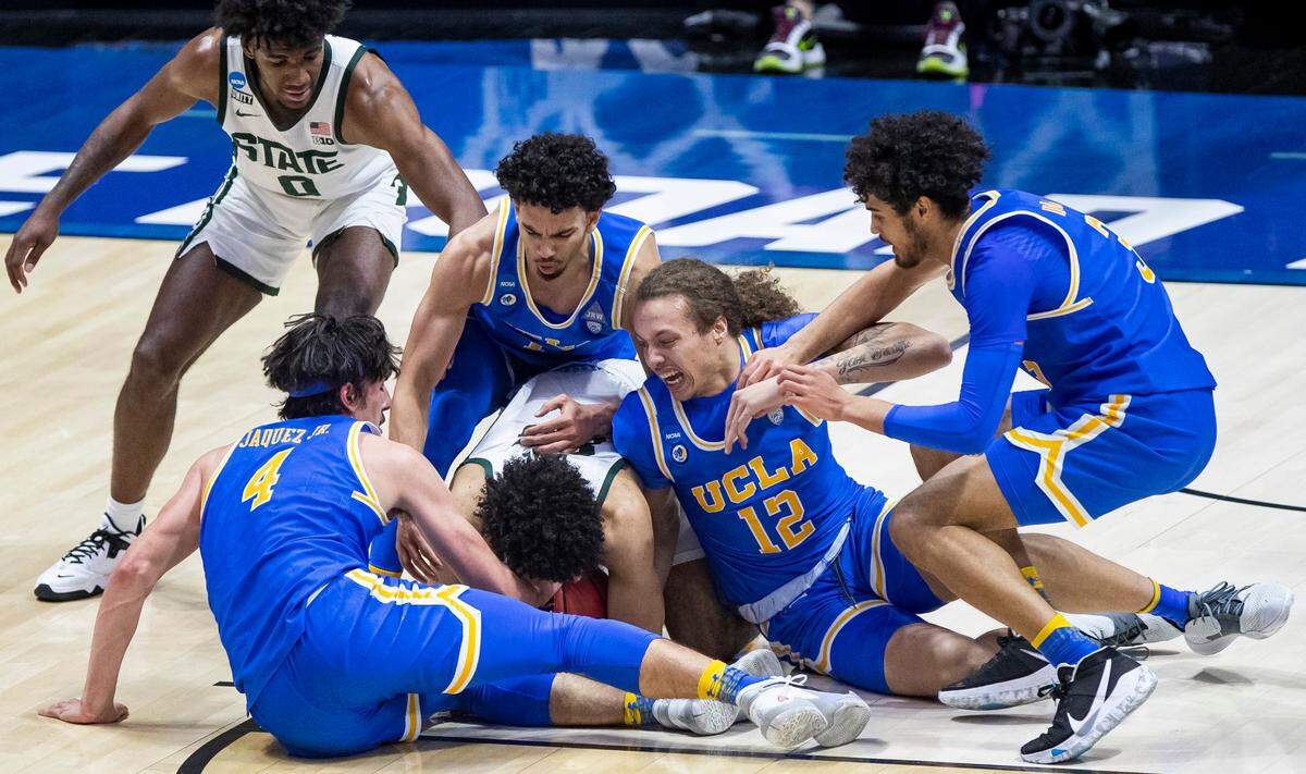 Michigan State’s Malik Hall, center, covers the ball during a scrum involving teammate Aaron Henry (0) and UCLA’s Jaime Jaquez Jr. (4), Jules Bernard, top/center, Mac Etienne (12) and Johnny Juzang, right, during the first half of a First Four game in the NCAA men’s college basketball tournament Thursday, March 18, 2021, at Mackey Arena in West Lafayette, Ind. (AP Photo/Robert Franklin)