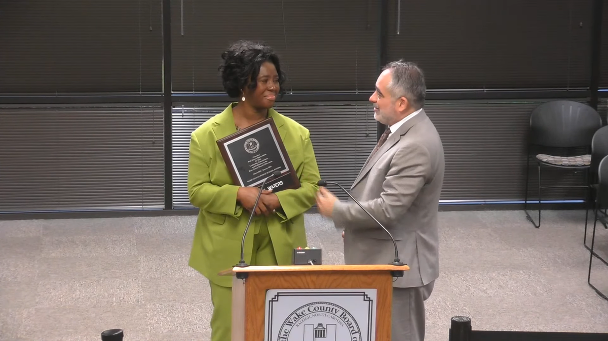 Former Wake County school board member Tara Waters receives a plaque from school board chair Chris Heagarty in Cary, N.C., on Jan. 9, 2024, for her service on the board.
