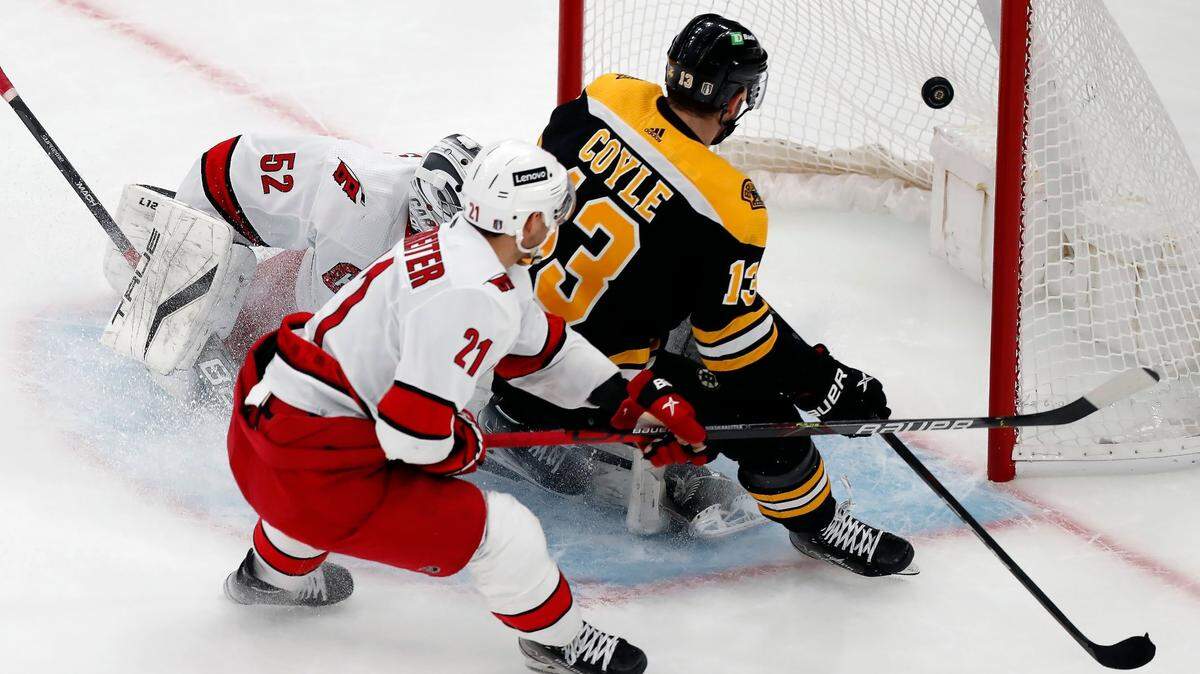 Boston Bruins’ Charlie Coyle (13) scores against Carolina Hurricanes’ Pyotr Kochetkov (52) during the first period of Game 3 of an NHL hockey Stanley Cup first-round playoff series, Friday, May 6, 2022, in Boston. (AP Photo/Michael Dwyer)