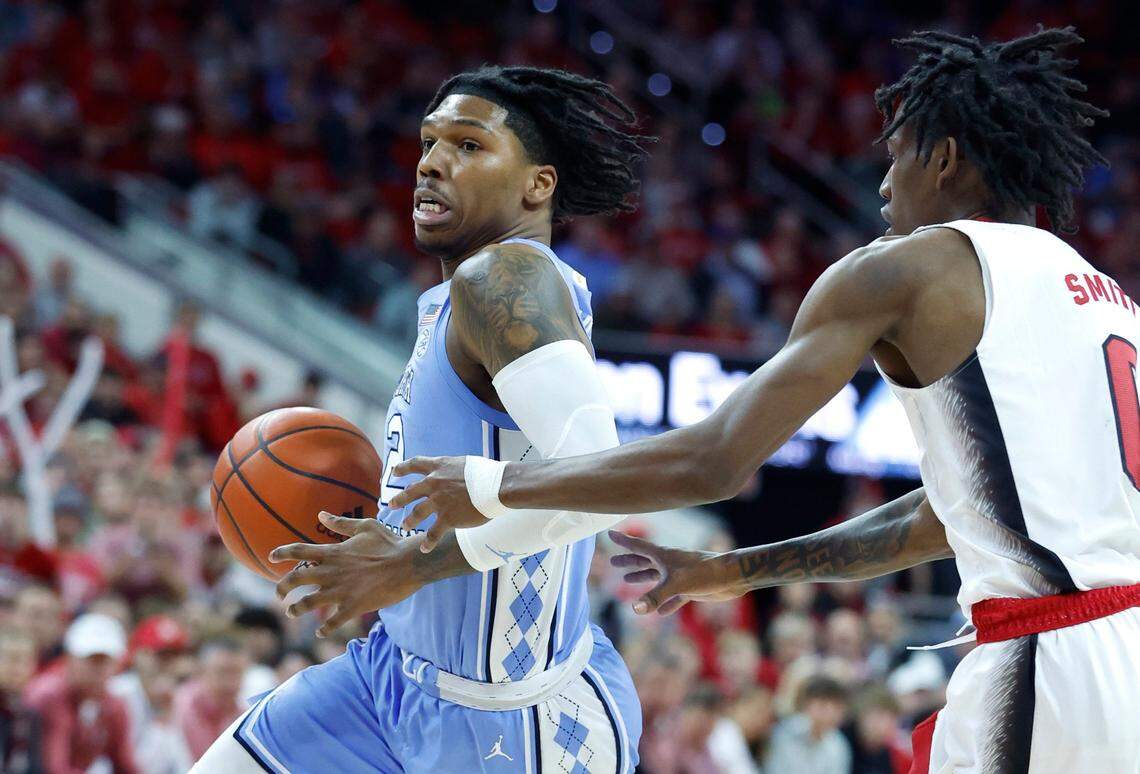 North Carolina’s Caleb Love (2) drives by N.C. State’s Terquavion Smith (0) during the first half of N.C. State’s game against UNC at PNC Arena in Raleigh, N.C., Sunday, Feb. 19, 2023.