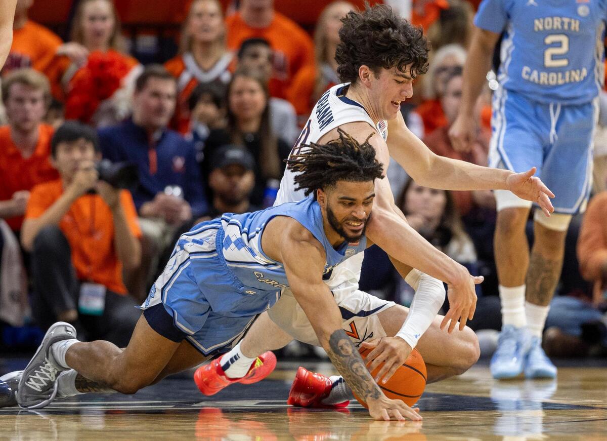 North Carolina’s R.J. Davis (4) battles for a loose ball with Virginia’s Blake Buchanan (0) during the first half on Saturday, February 24, 2024 at John Paul Jones Arena in Charlottesville, Va.