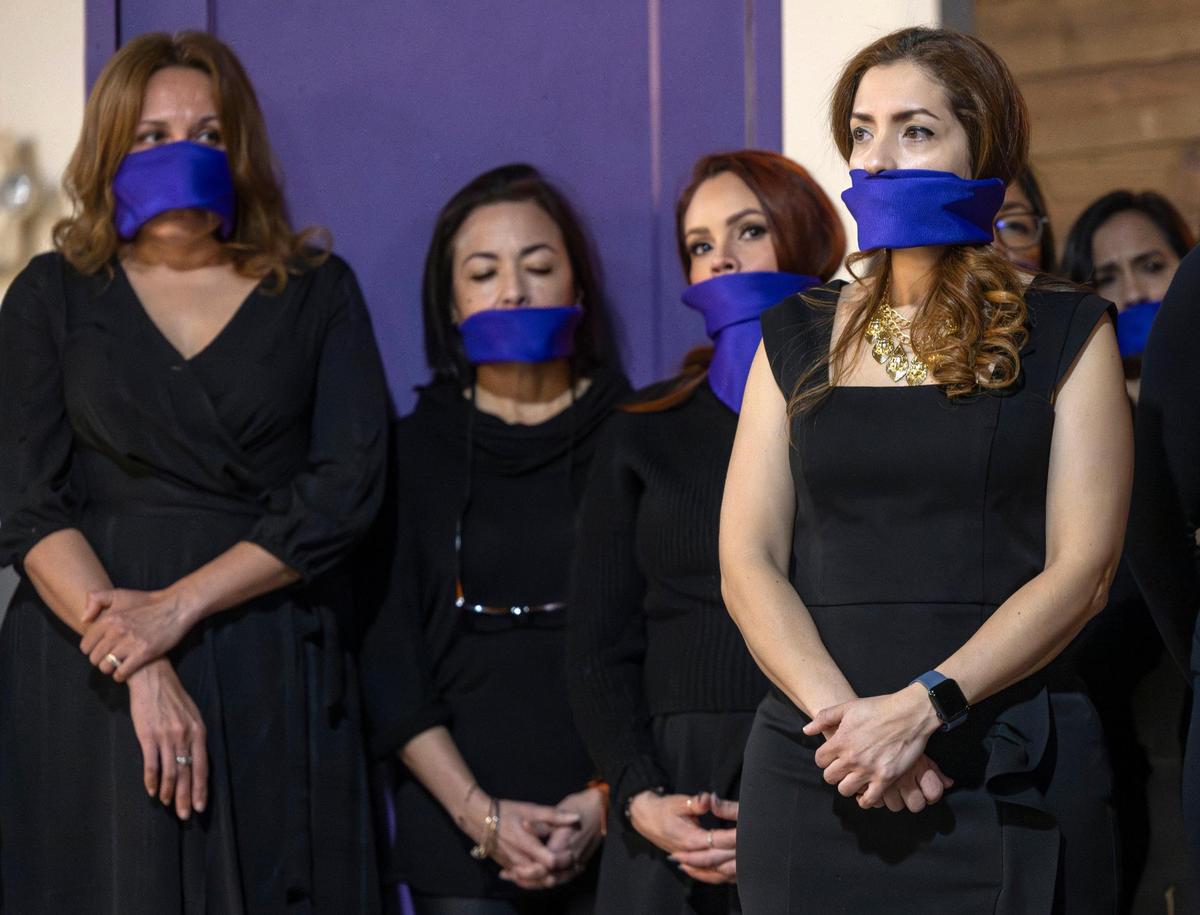 Laura Gonzqui, right, was part of a group of women who covered their mouths to memorialized North Carolina women who have been victims of domestic violence at El Centro Hispano on Friday, March 8, 2024 in Raleigh, N.C. The gathering on International Women’s Day, was to raise awareness to the increase in femicide in North Carolina.