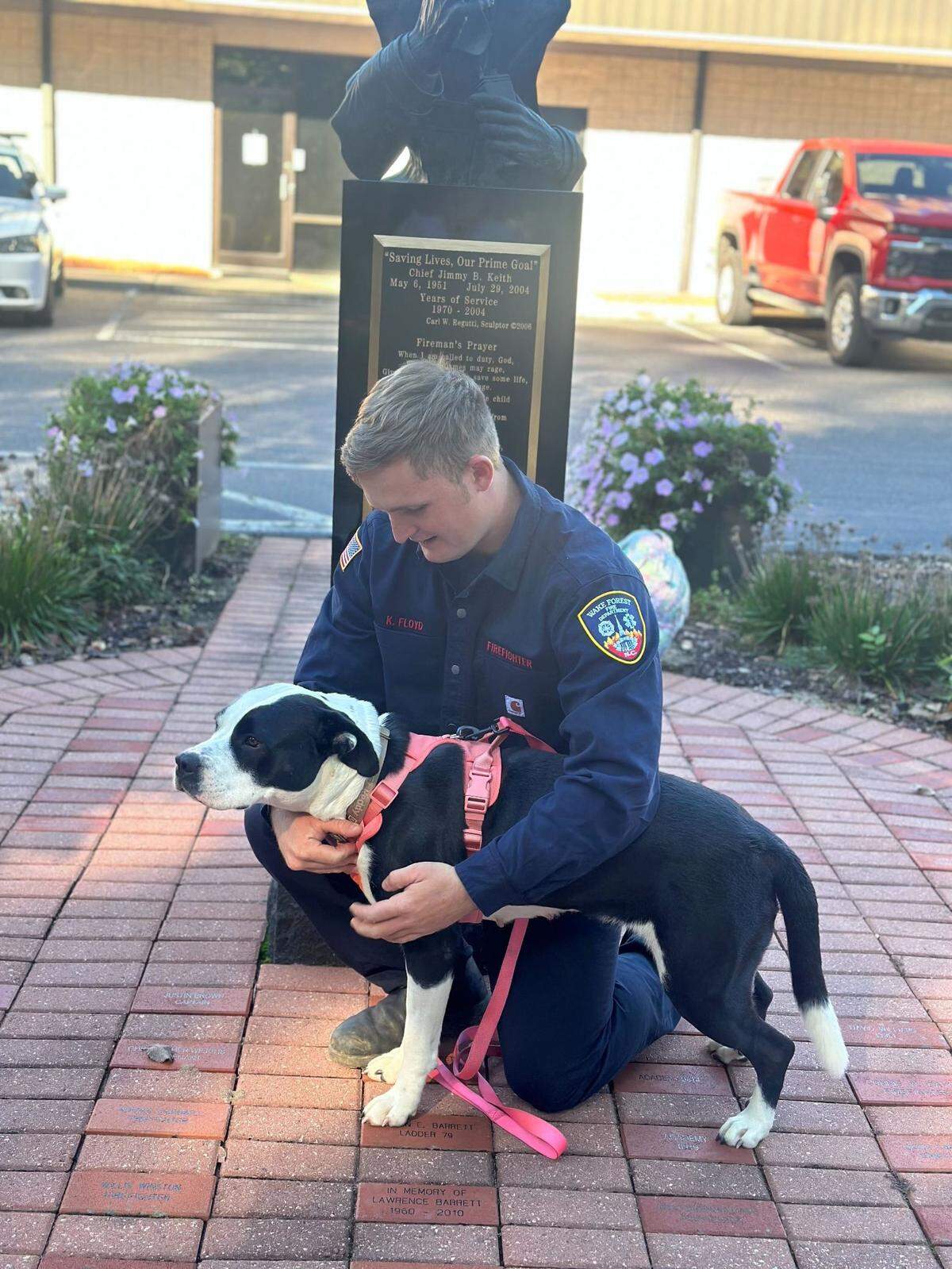 Wake Forest firefighter Korey Floyd, 23, poses with Lulu the dog Oct. 9, 2024, at the Wake Forest Fire Department. Floyd and his colleagues rescued Lulu in Mitchell County while helping with Hurricane Helene rescue and relief efforts.