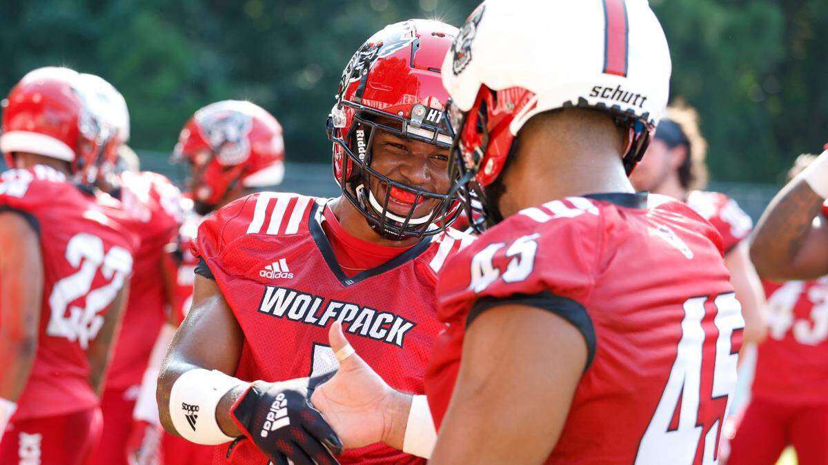 N.C. State’s Isaiah Moore (1) smile as he greets Davin Vann (45) during N.C. State football’s first practice of fall camp in Raleigh, N.C., Wednesday, August 3, 2022.